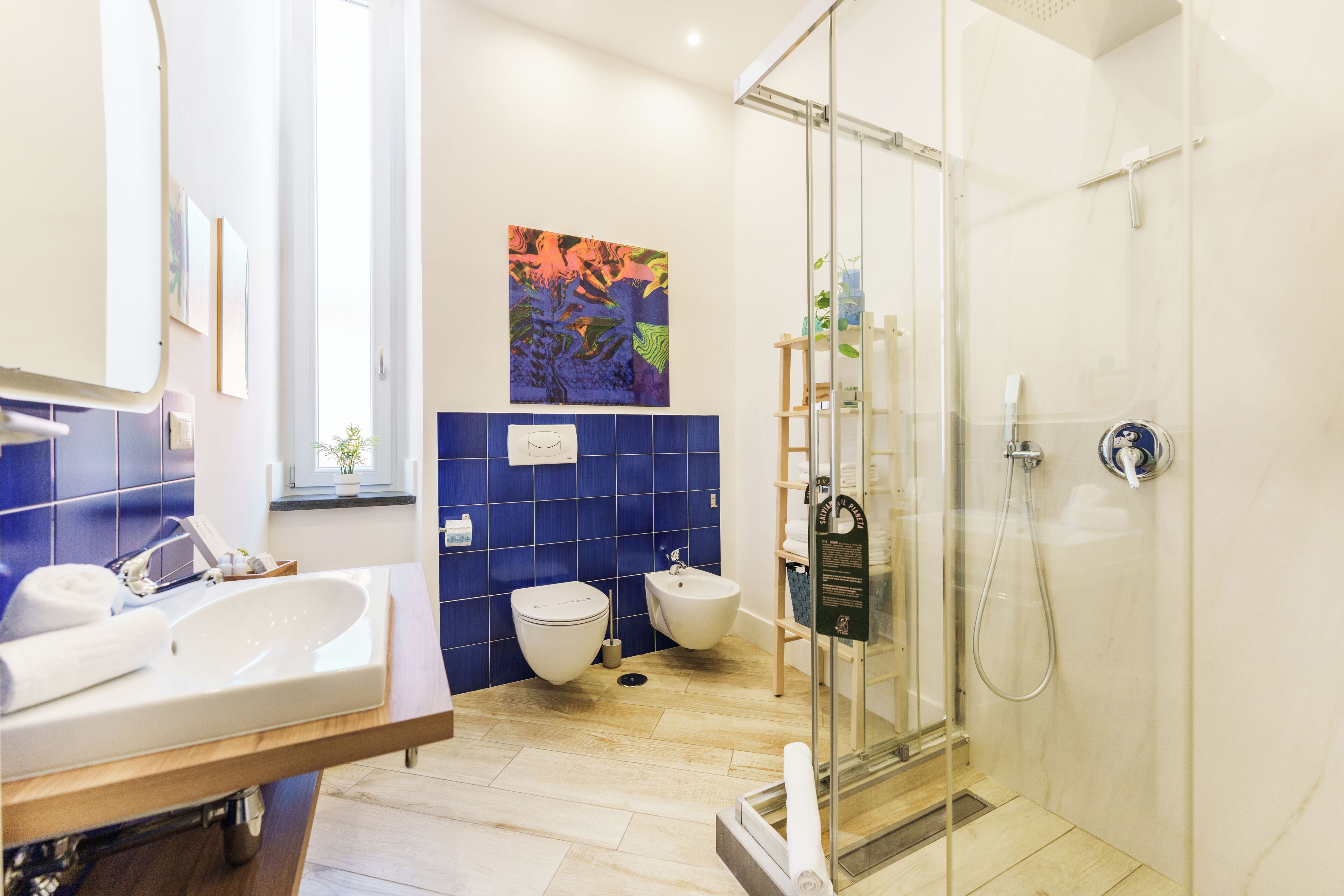 Ein modernes Badezimmer mit einer Glasdusche, einem weißen Waschbecken und einem Bidet.