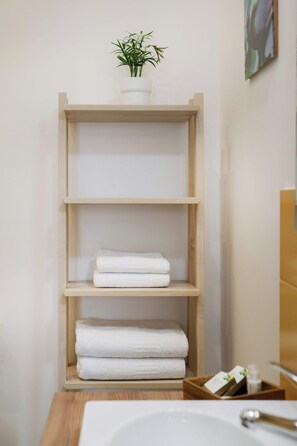 Habitación cuádruple Deluxe, 1 cama de matrimonio con sofá cama, en una planta alta | Baño | Ducha y cabezal de ducha tipo lluvia