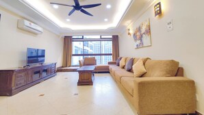 A living room with a ceiling fan, a TV, a sofa, and a large window with curtains. - Pavilion Fahrenheit 88 - AJ home (Kuala Lumpur)