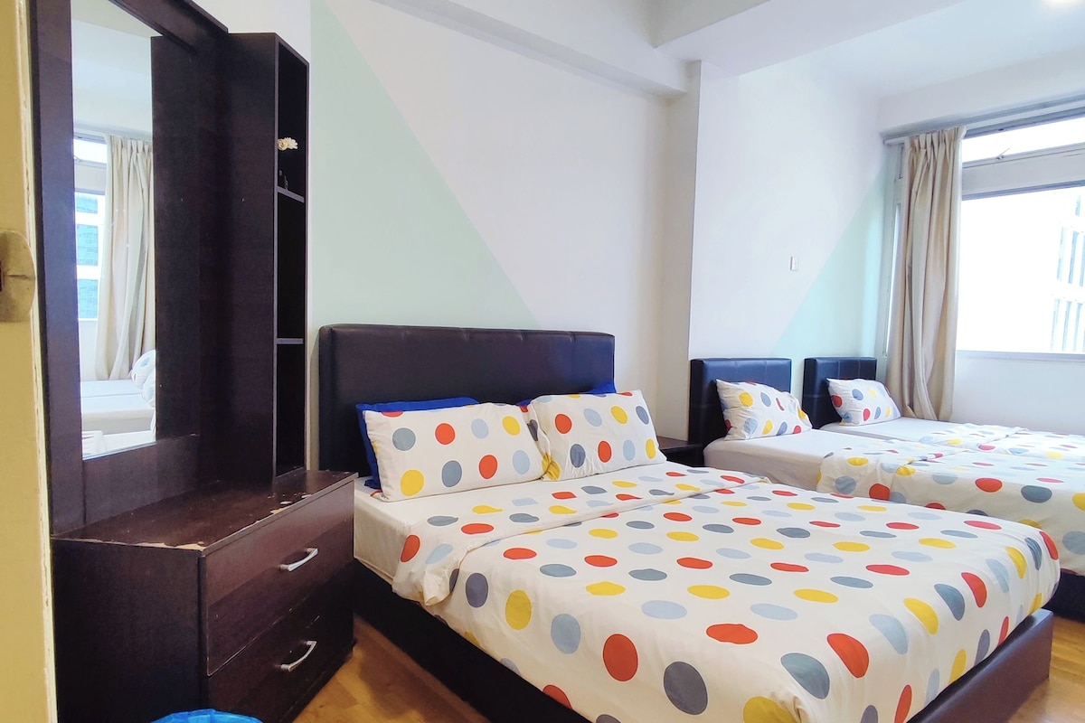 A hotel room with two beds, a dresser, a mirror, and a window.