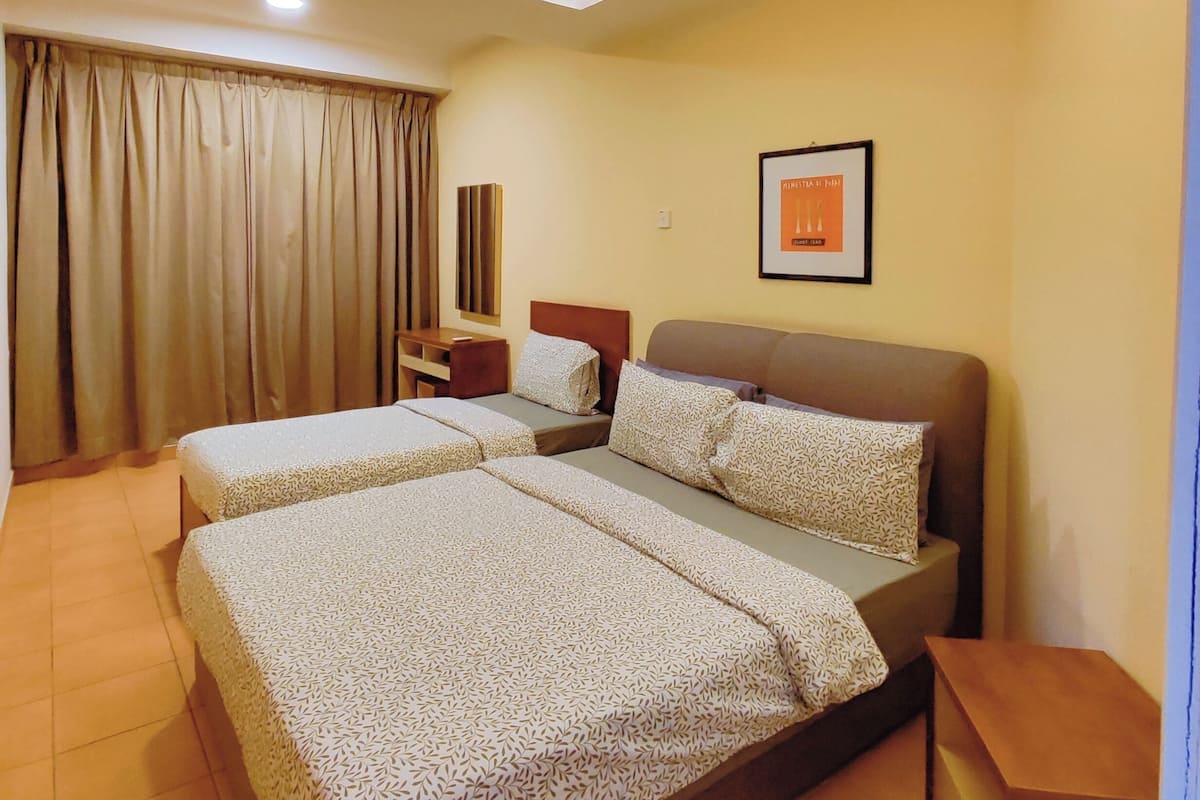 A hotel room with two beds, a ceiling fan, a nightstand, a framed picture, and a window with curtains.