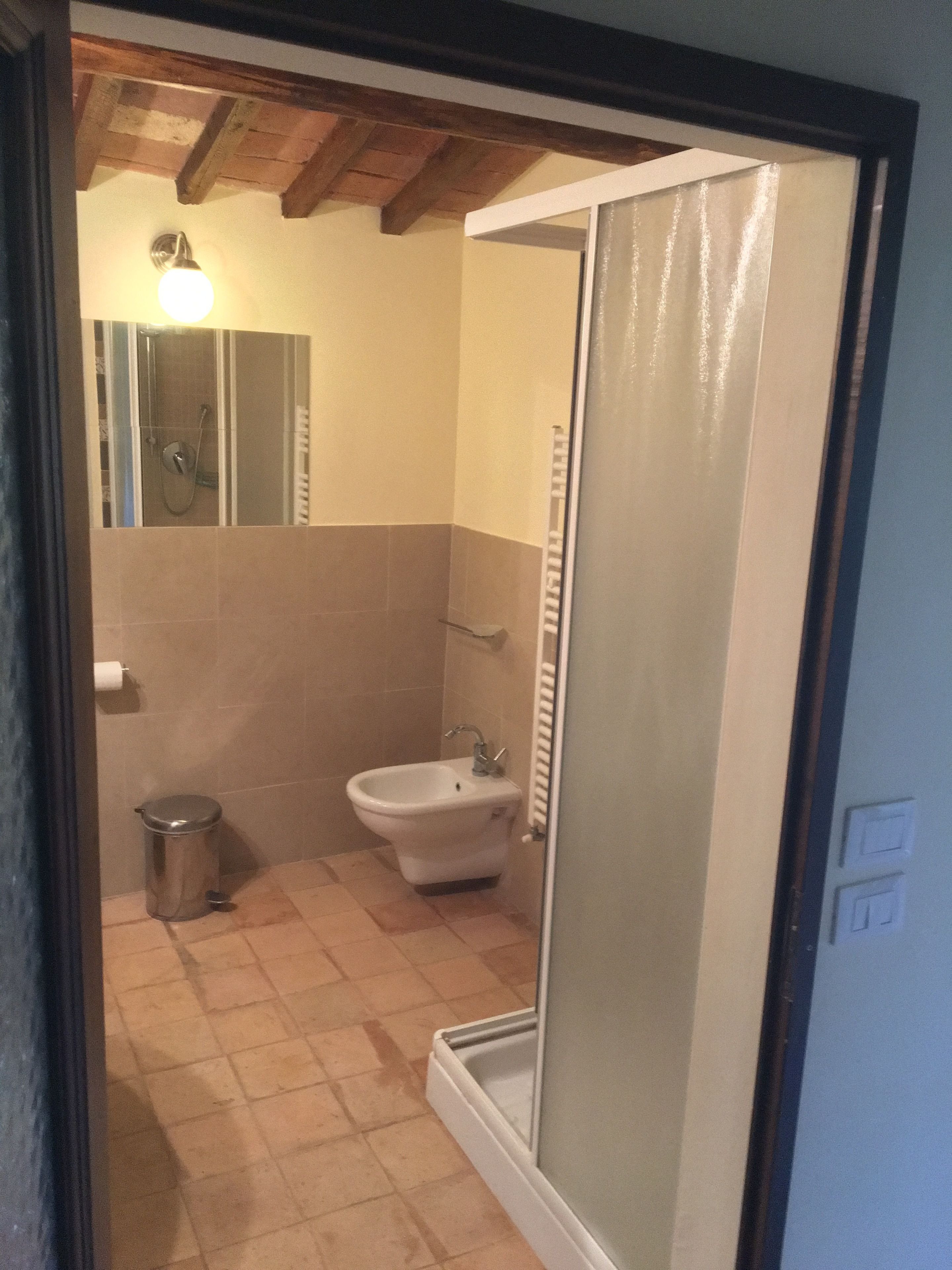 Une salle de bain équipée d’une douche, d’un bidet et de toilettes.