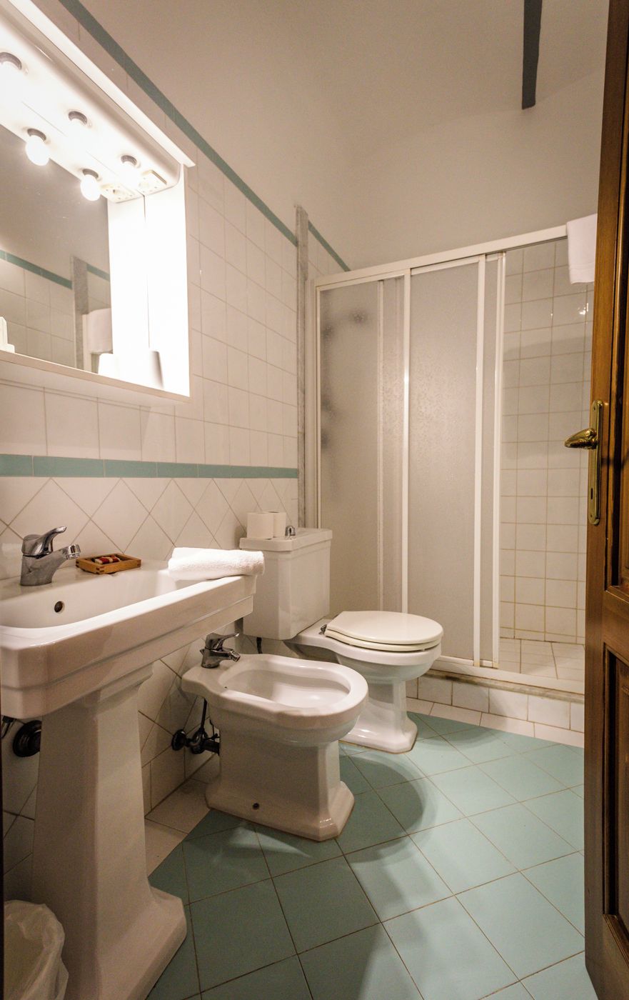 Un bagno con lavandino, bidet, wc e zona doccia.
