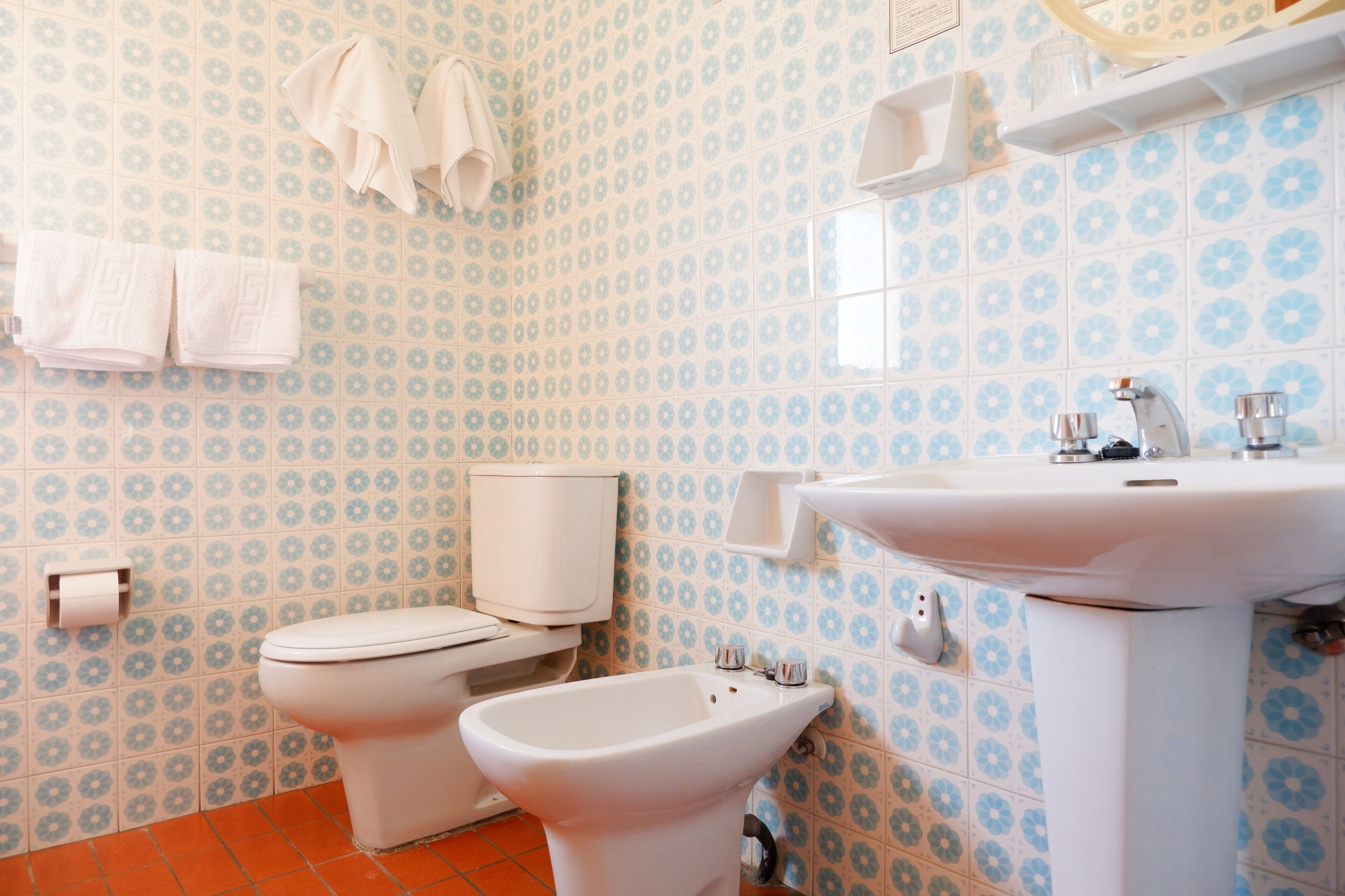 Un baño con inodoro, bidé y lavamanos, todo en color blanco.