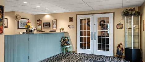 A reception area with a counter, a door with glass panels, and a display cabinet.