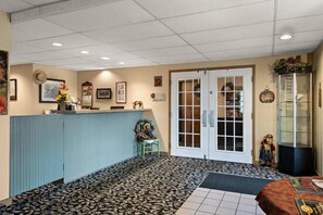 A reception area with a counter, a door with glass panels, and a display cabinet. - Country Living Inn (Lancaster)