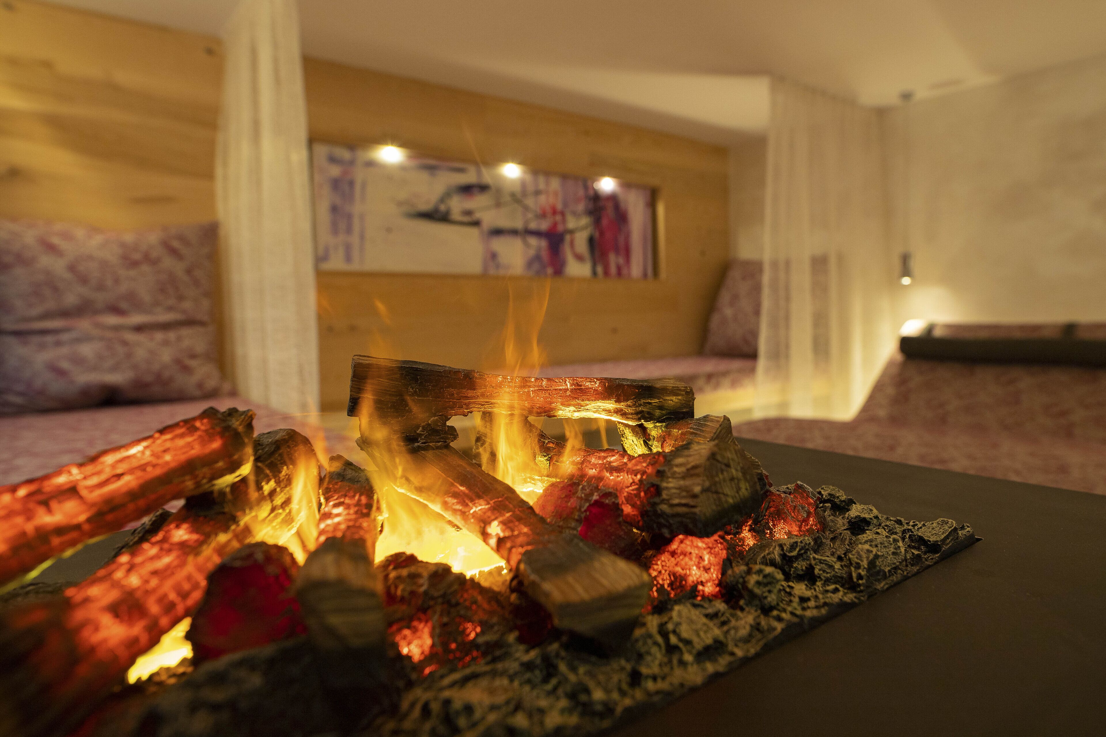 A room with a fireplace, a couch, and a painting on the wall.