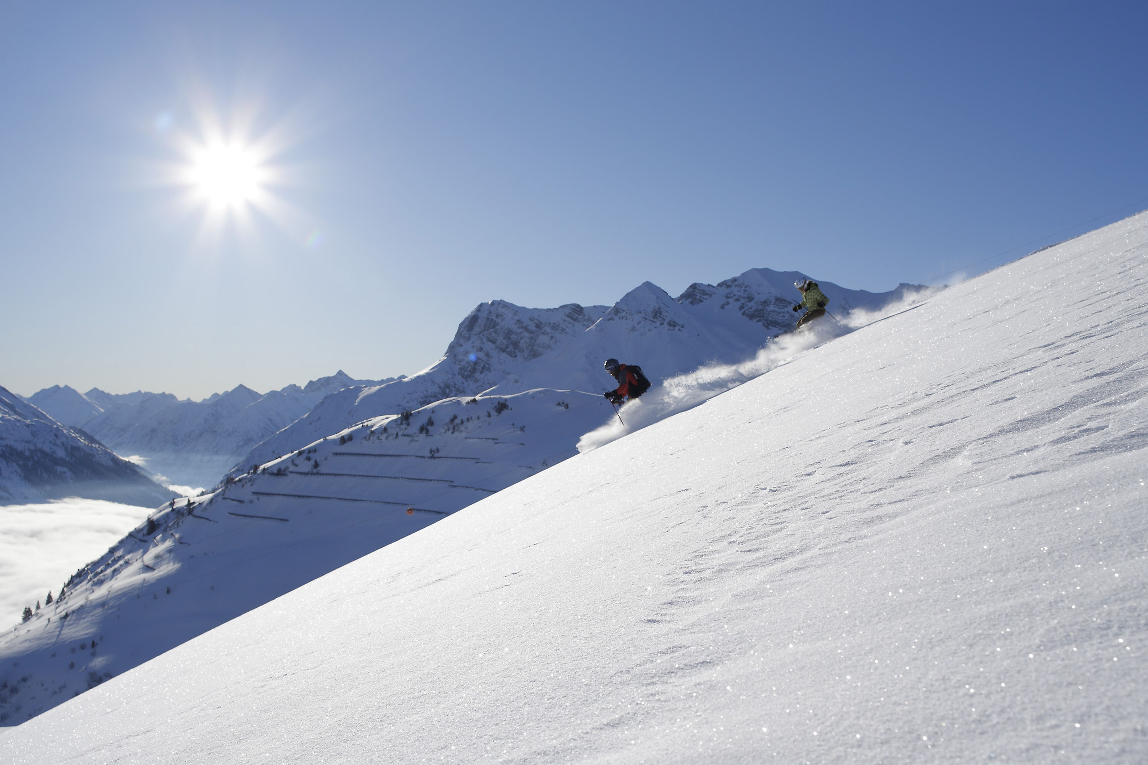 Ein verschneiter Berghang mit einem sich bewegenden Skifahrer.