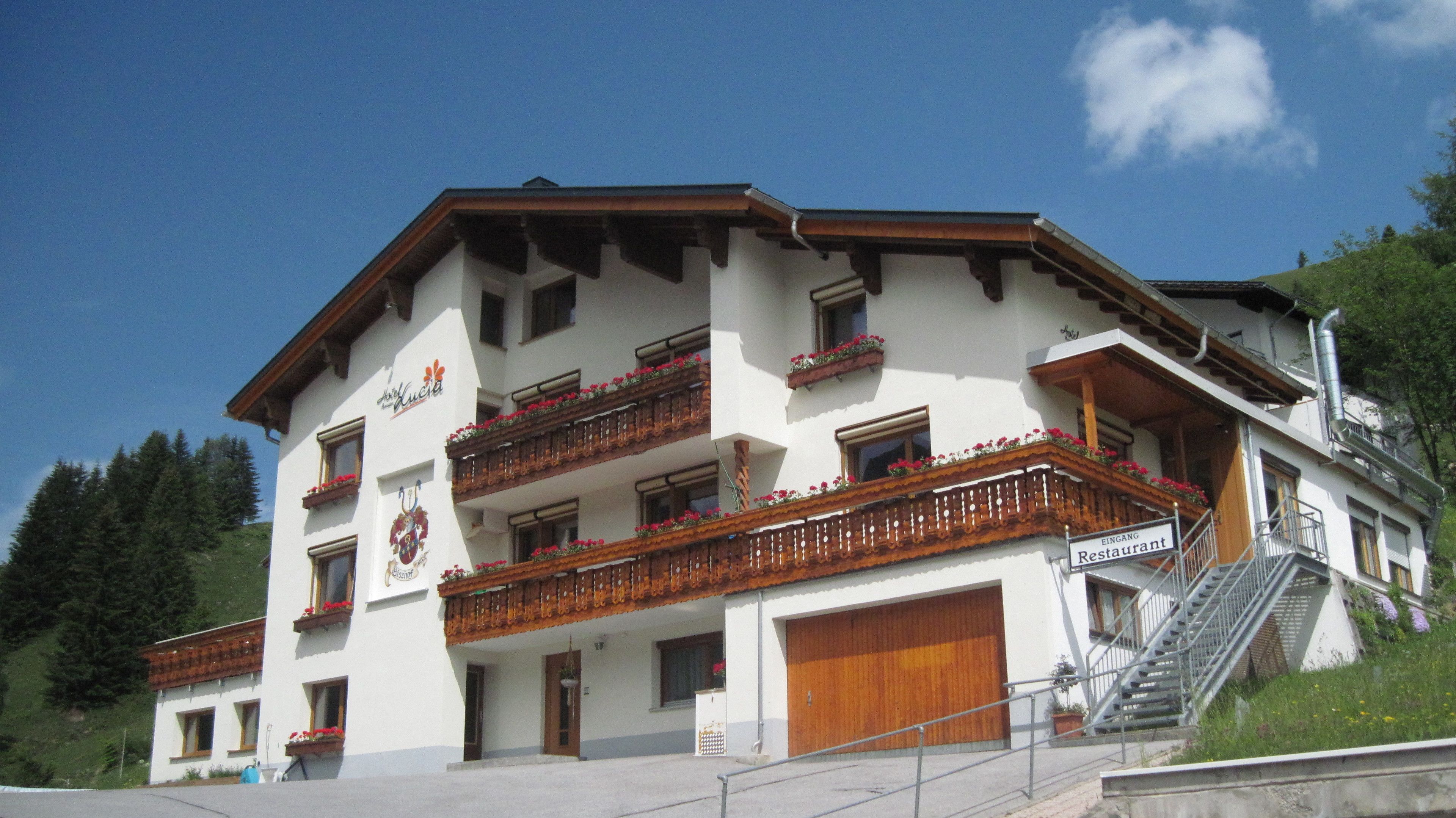 A multi-story hotel with balconies, a staircase, and a sign indicating a restaurant.