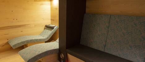 A sauna with wooden walls and a bench.