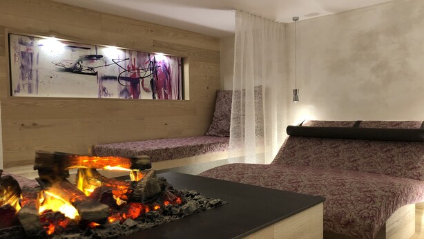 Una sala de estar moderna con chimenea, un sofá y una obra de arte colgada en la pared.