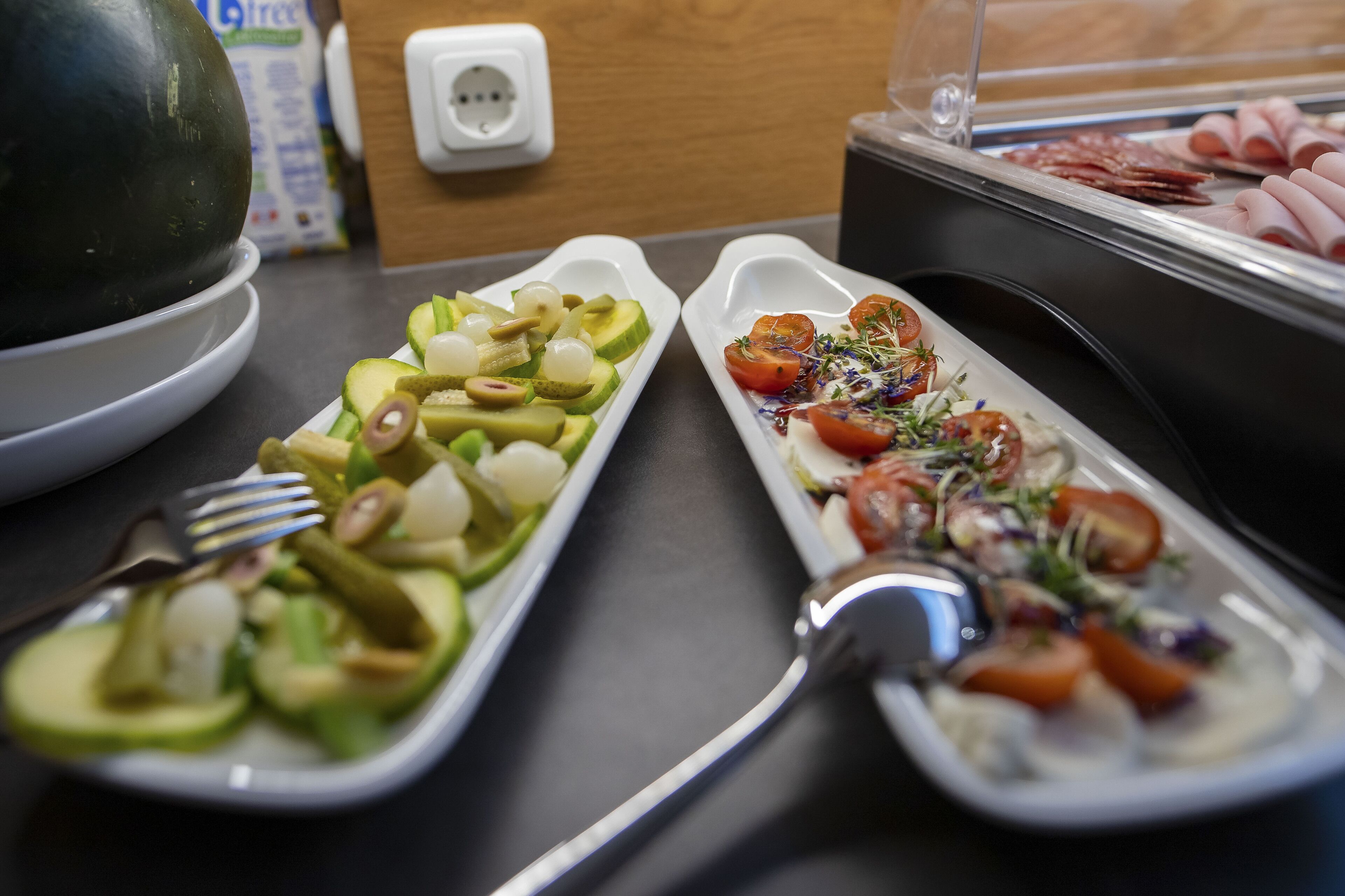 A buffet with various dishes including salads and meats.
