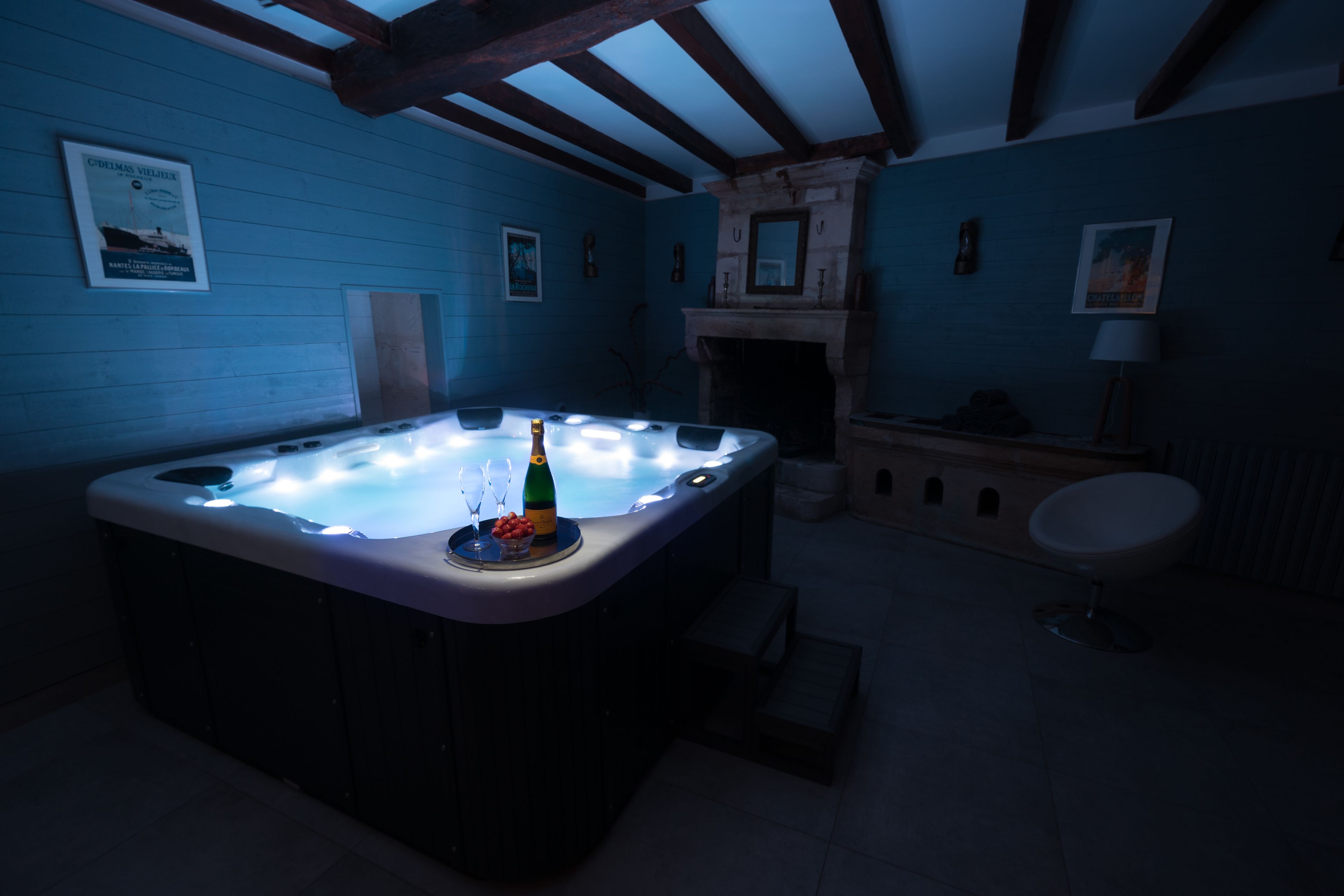 A room with a hot tub, a fireplace, and a bar area.