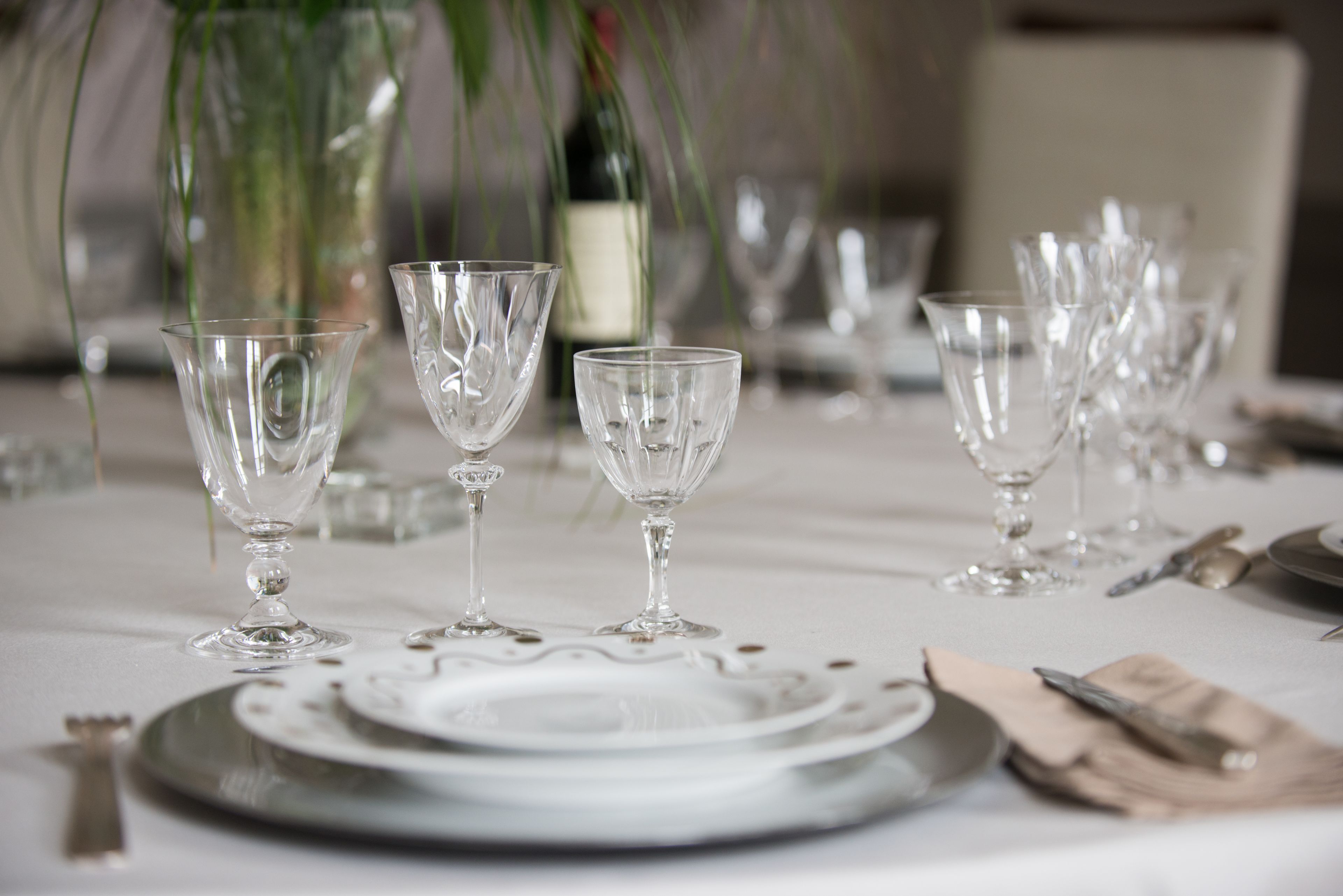 A table set for a formal dining occasion with clear glassware and silverware.