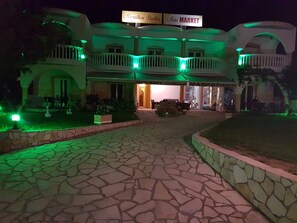 A building with a stone-paved entrance, a sign for 'Marathon Studios Mini Market', and a visible storefront with a sign for 'Fresh Fruit'. - Marathon Studios &Apartments (Zakynthos)