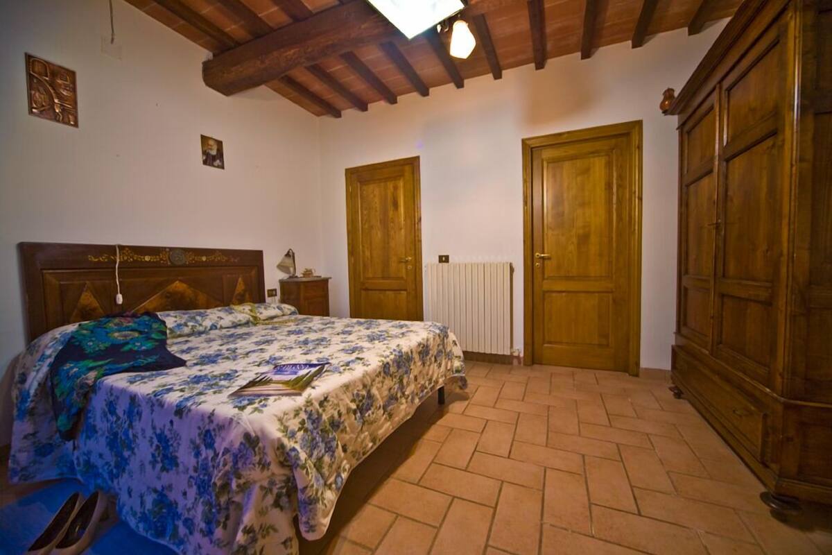 Une chambre à coucher avec un lit en bois, un radiateur et des armoires en bois.