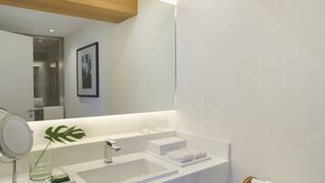 A modern bathroom with a wooden ceiling, a large mirror, two sinks, and a towel rack.
