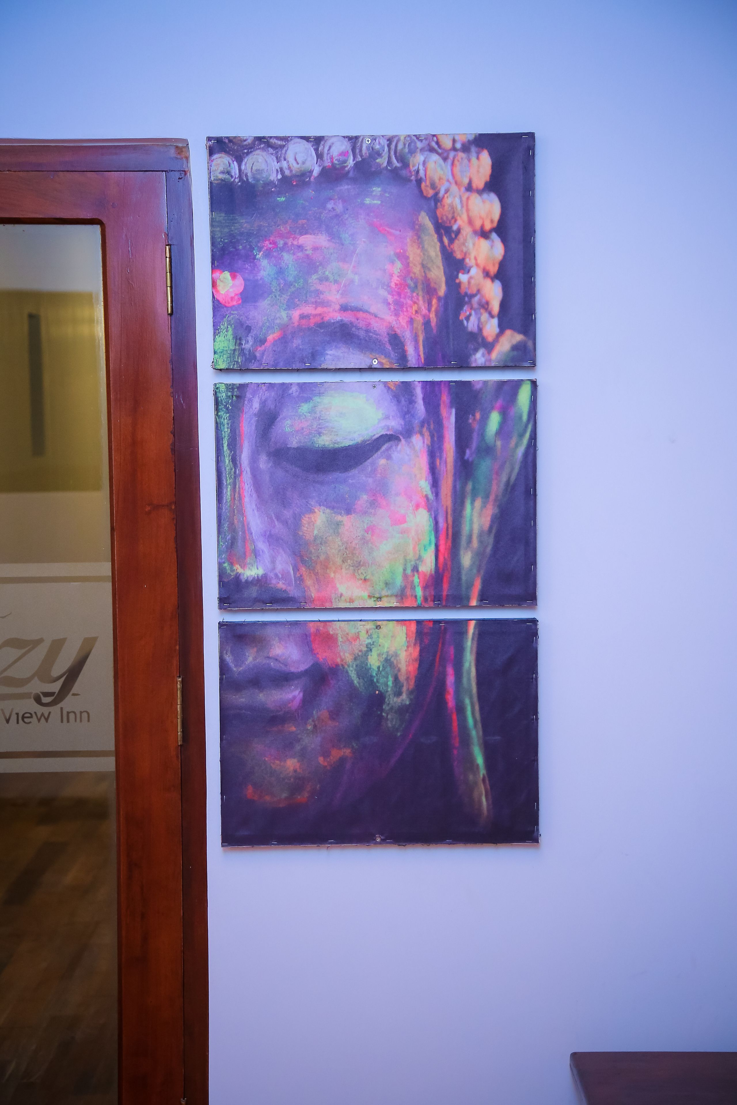 A wall with three abstract paintings.