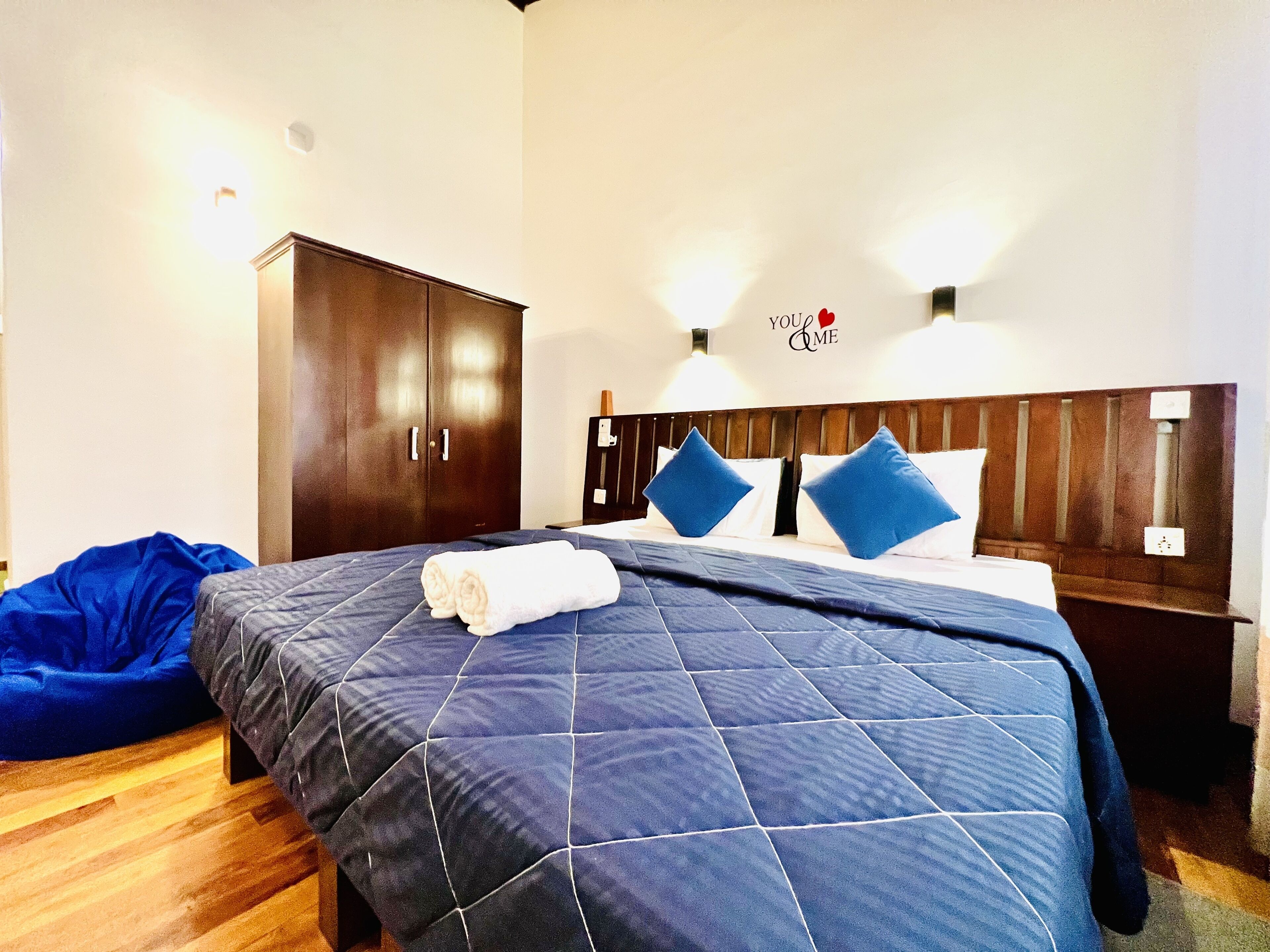 Una habitación de hotel con una cama grande, un armario y un cartel en la pared.