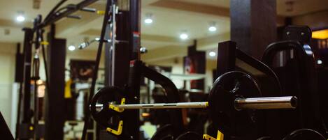 A gym with weightlifting equipment, including barbells and weight plates.