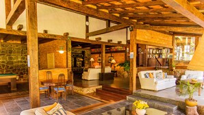 A spacious lobby with a pool table, comfortable seating, and a bar area. - Pousada das Araras (Petrópolis)