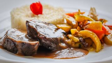 Un plato de comida con bistec, arroz y verduras.