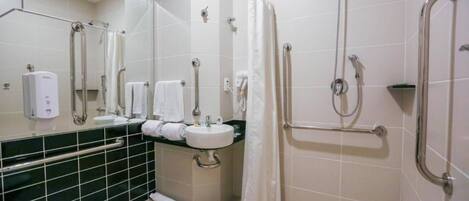 Ein modernes Badezimmer mit Toilette, Waschbecken und Duschbereich.