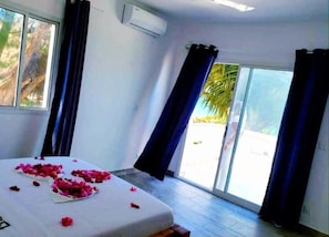 Une chambre dotée d’un lit, d’une porte-fenêtre coulissante et d’un appareil de climatisation.