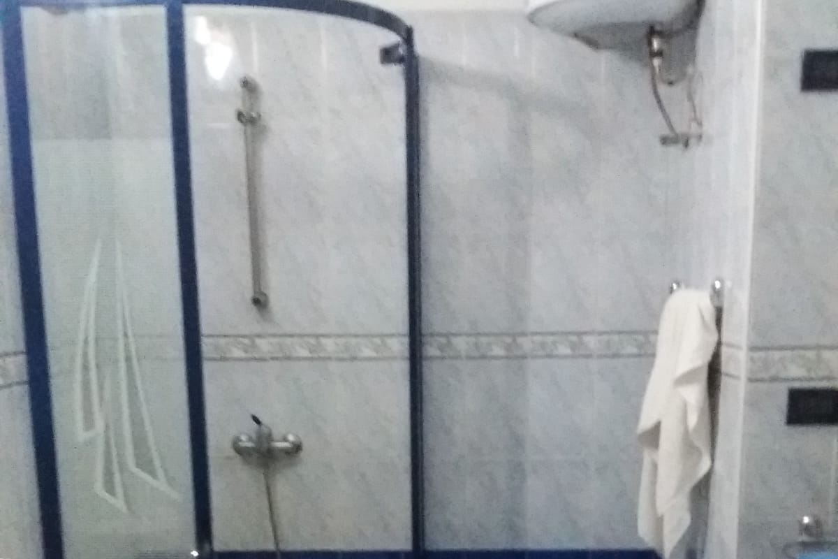 A bathroom with a shower, toilet, and sink.
