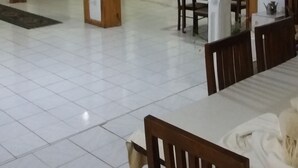 A spacious room with a tiled floor, wooden furniture, and a dining area with a table and chairs. - Ka Mario Guesthouse (Kandy)