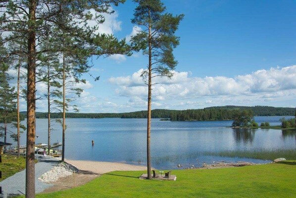 A lakeside property with a dock, a grassy area, and a clear view of the lake and surrounding forest. - Hotelli Viikinhovi (Keuruu)