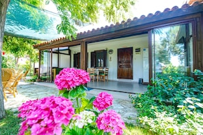 Una casa moderna con un porche cubierto, un comedor y un amplio ventanal que da a una habitación.