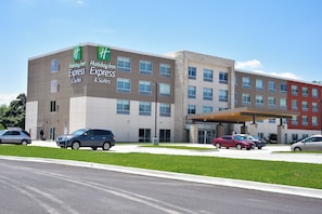A Holiday Inn Express & Suites hotel with a modern design, multiple floors, and a parking lot.