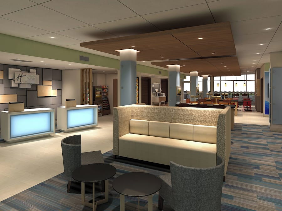 A modern lobby with a reception desk, seating area, and a large window providing natural light.