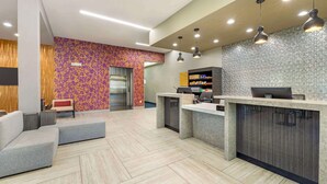 A modern reception area with a counter, seating, and a patterned wall. - Best Western Plus Temecula Wine Country Hotel &Suites (Temecula)