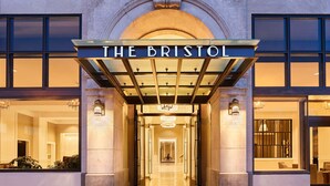 La entrada del hotel The Bristol, con un gran arco y un camino despejado que lleva al interior, y un letrero sobre la entrada.
