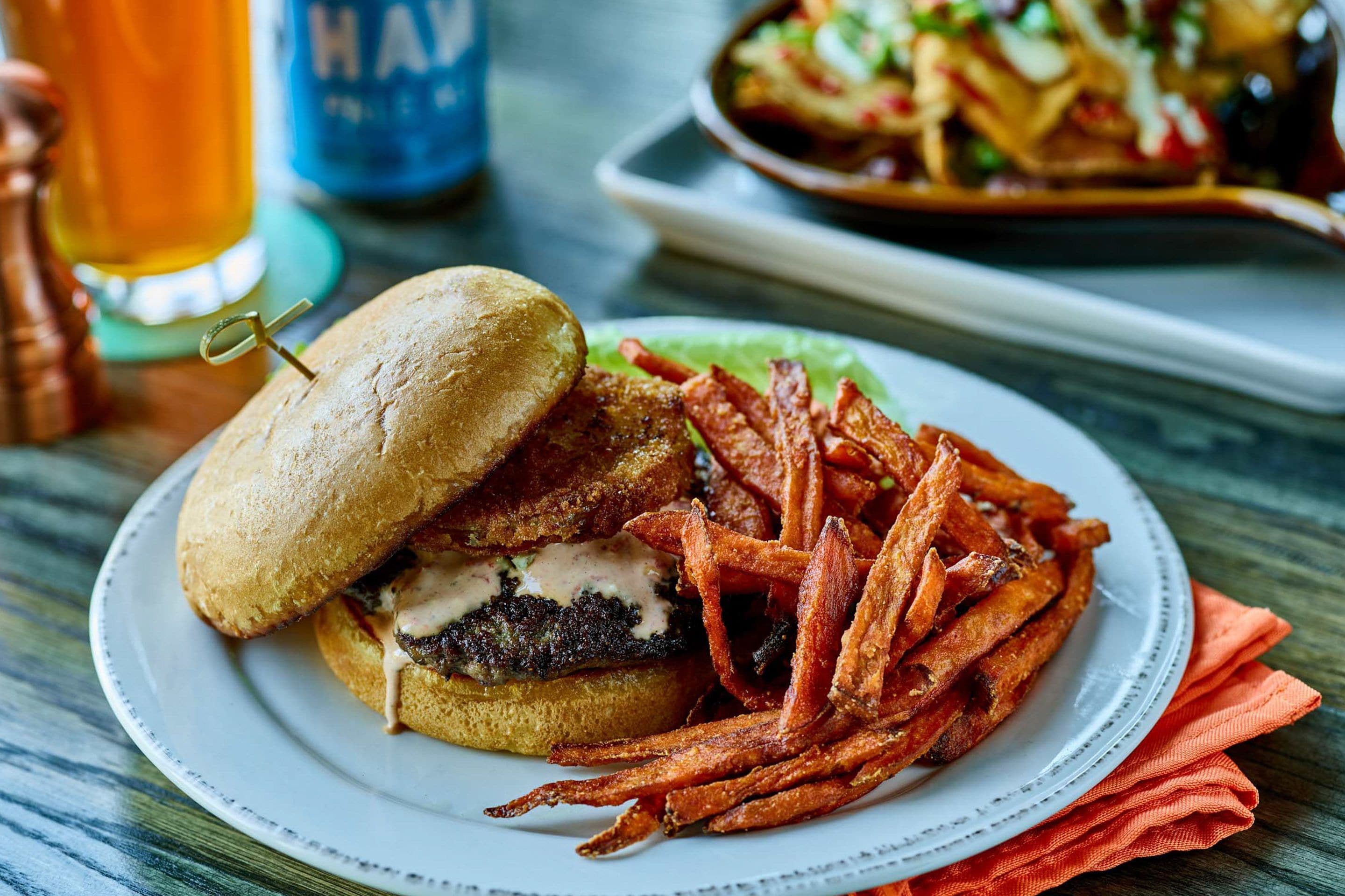 A plate with a burger and fries on a table.