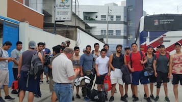 A group of people standing in front of a building with a sign that reads 'El Náufrago Casa de Alquiler.'