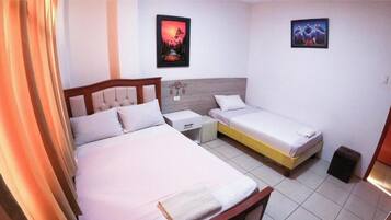 Un dormitorio con dos camas, una mesita de noche y una lámpara de pared.