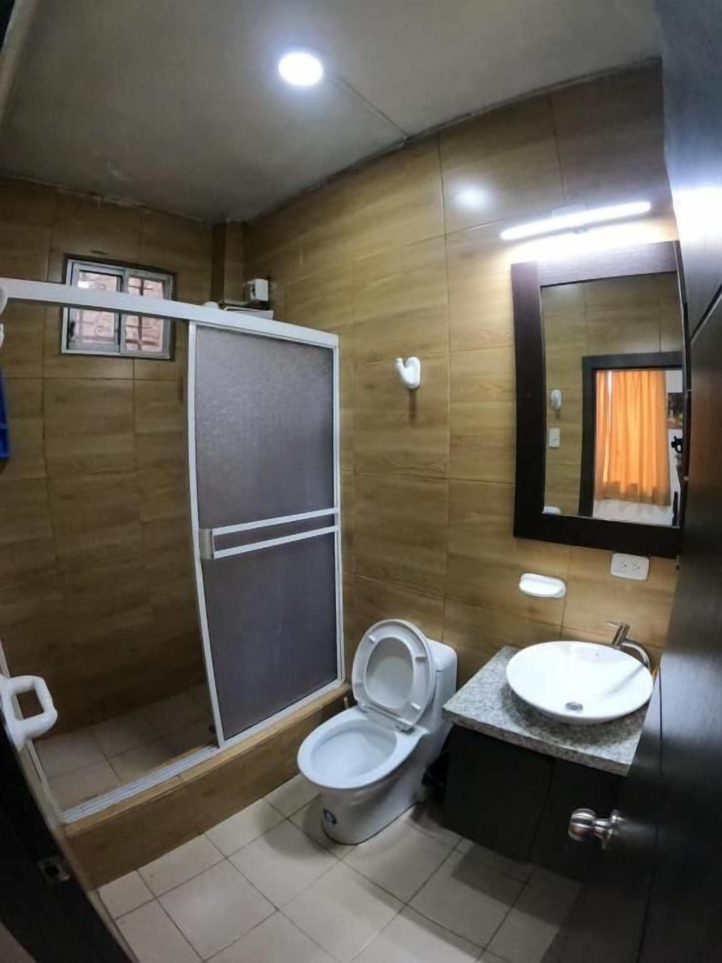 Une salle de bain comprenant des toilettes, un lavabo et un espace douche.