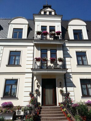 A large, two-story building with a symmetrical facade, multiple windows, and a central entrance with a staircase. - Villa Le Grand (Boryspil)