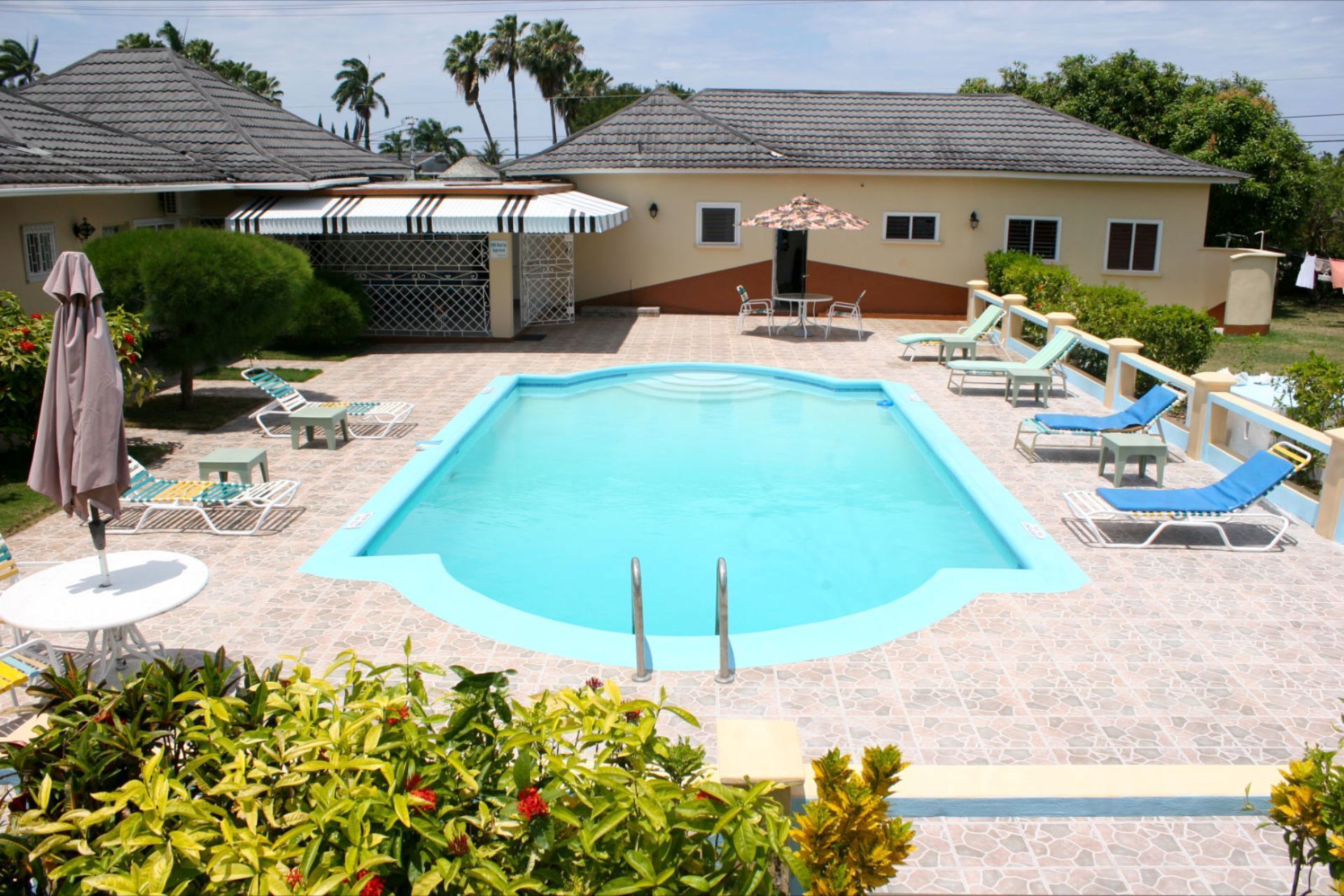 室外游泳池，池畔遮阳伞，日光浴躺椅