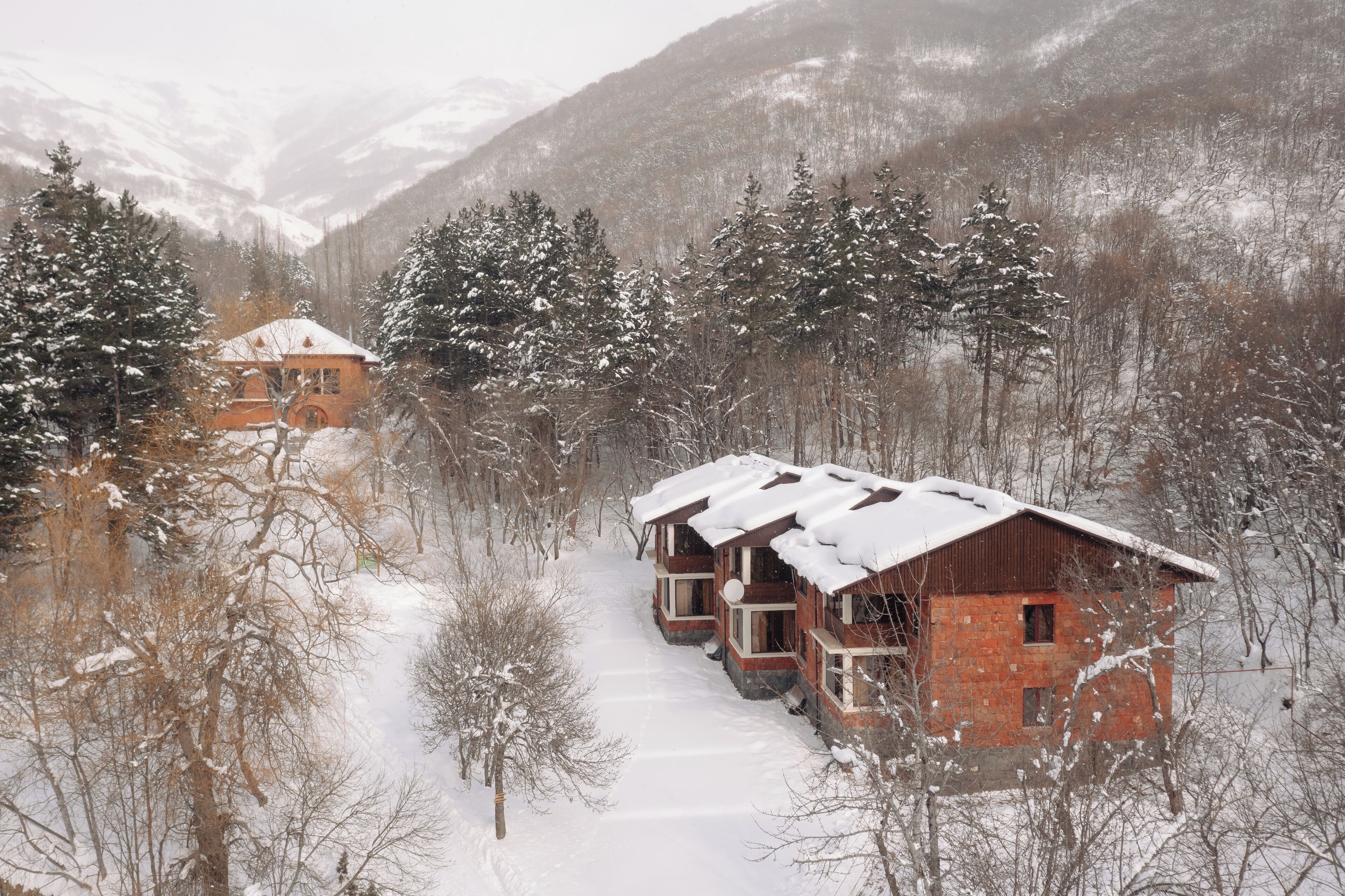 A snow-covered mountain village with traditional wooden houses.