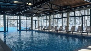 Piscine couverte, piscine extérieure, parasols de plage, chaises longues
