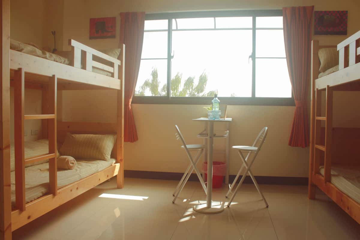 A room with bunk beds, a small table, and chairs.