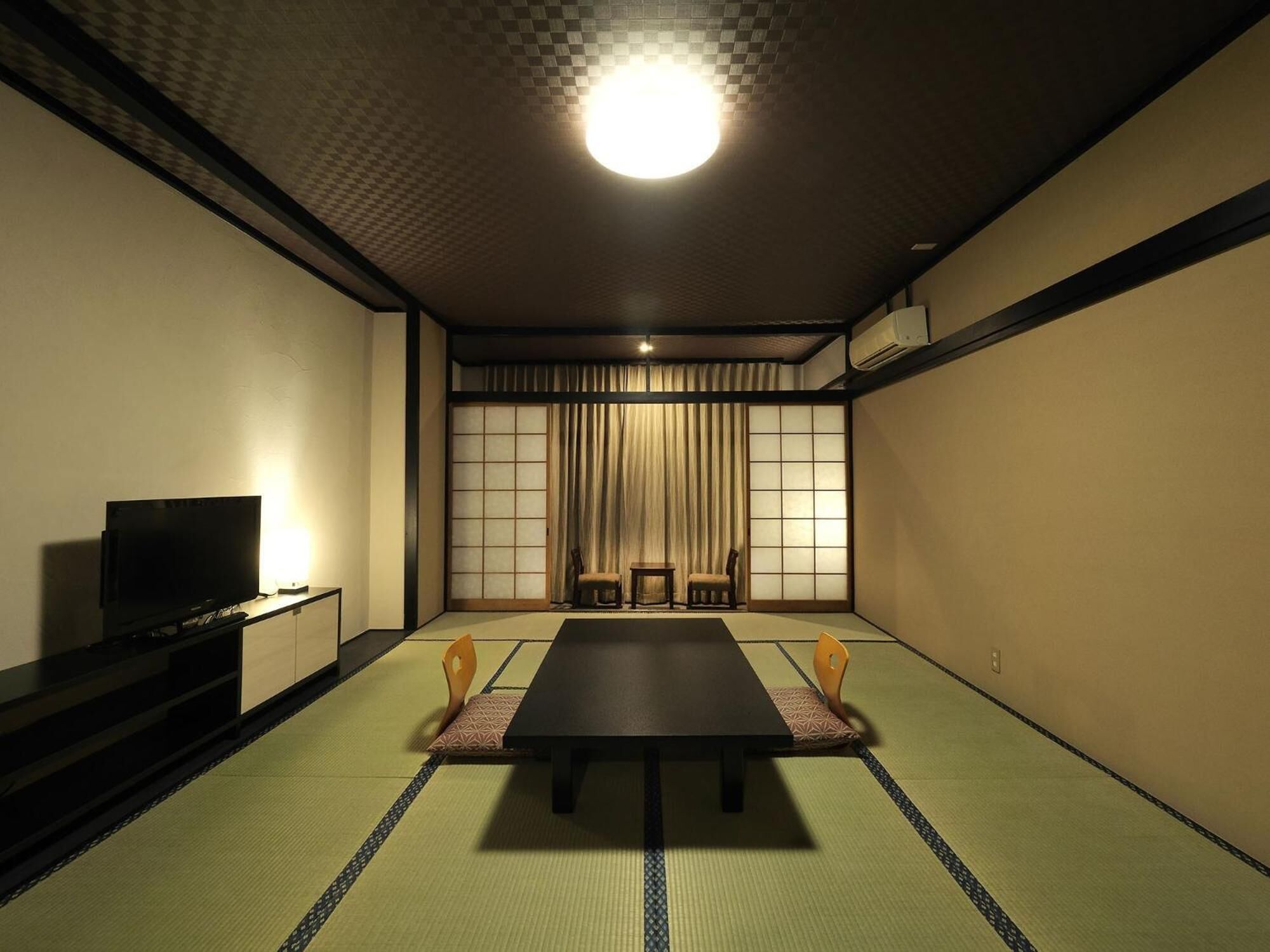 A traditional Japanese-style room with tatami flooring, a low table, and sliding doors.