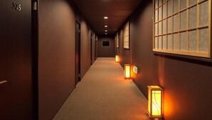 A hallway with doors numbered 505, recessed lighting, and wall-mounted lanterns. - Tokiwa Hotel (Nasushiobara)