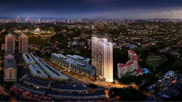 Un grand hôtel à plusieurs étages, entouré d’un mélange de bâtiments résidentiels et commerciaux, et doté d’un vaste espace ouvert avec un stade.