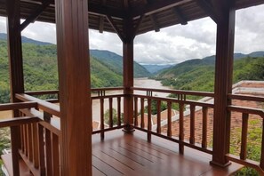 Overlooking a serene valley, this gazebo offers a tranquil view of a river flowing through lush green hills.