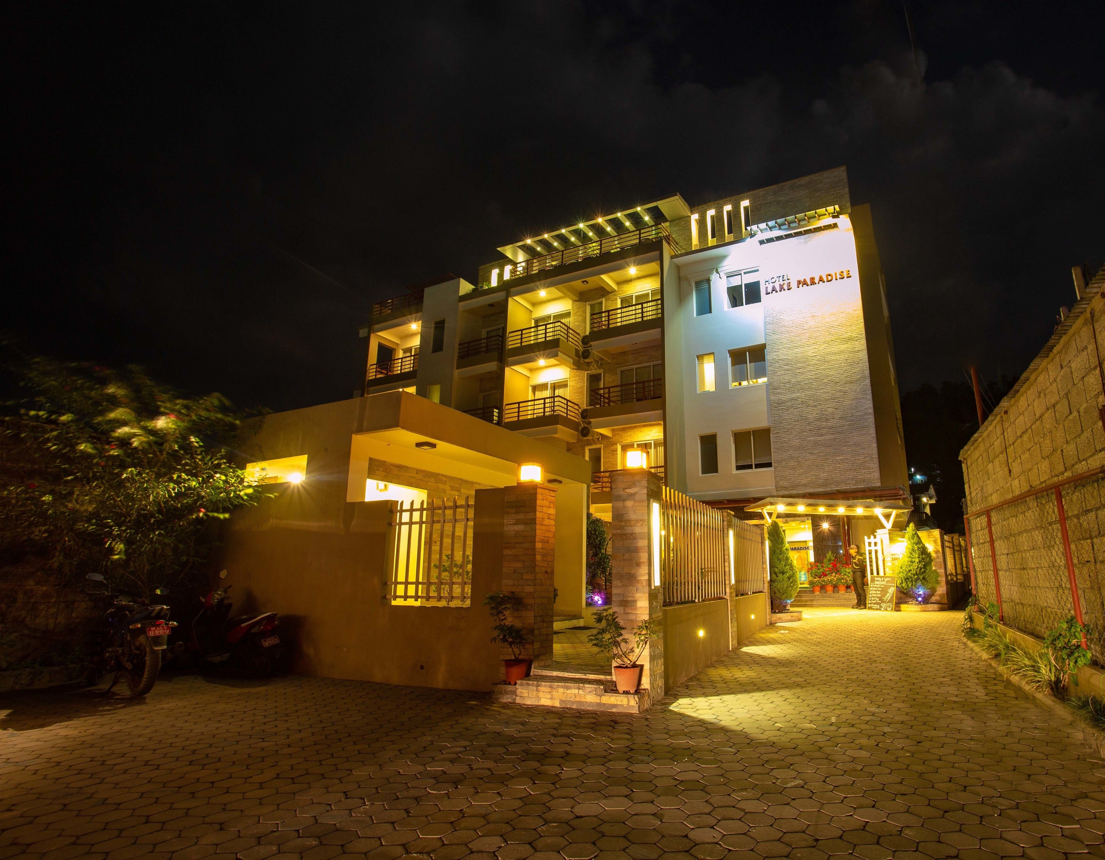 A multi-story hotel with a well-lit entrance and a visible balcony on the upper floor.